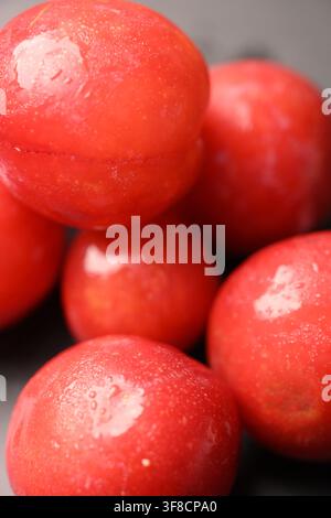 Prunes rouges fraîches avec gouttes d'eau présentées en compositions en vue de dessus Banque D'Images