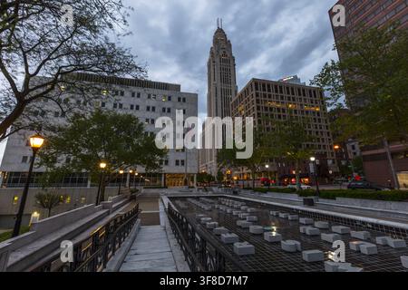 Vue de la tour historique LeVeque s'élevant au-dessus d'une fontaine moderne et d'un paysage urbain au crépuscule dans le centre-ville de Columbus, Ohio, États-Unis. Banque D'Images