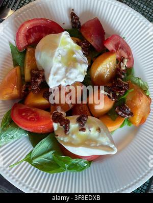Flat Lay d'une salade gourmande fraîche aux pêches d'Oregon et au basilic avec fromage Burrata et garniture de noix de walnut confites, 2026, États-Unis Banque D'Images