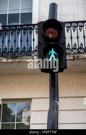 Signal de passage piéton vert illuminé sur un feu de circulation devant une architecture traditionnelle à York, Angleterre Banque D'Images