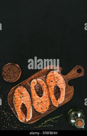 Steaks de saumon sur une planche en bois avec des épices Banque D'Images