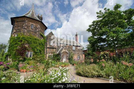 Le Gardener's Cottage au RHS Garden Bridgewater, Salford, entouré de conteneurs et de bordures remplis de plantes attrayantes pour les abeilles et les papillons. Banque D'Images