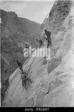 Travailleurs de haute altitude à l'œuvre sur les tours d'admission de l'Arizona du barrage Hoover, à environ 550 pieds au-dessus du fleuve Colorado, avec le côté Nevada du canyon en arrière-plan, pendant les travaux de construction le 28 juillet 1932. Banque D'Images