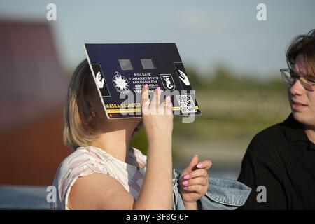 Varsovie, Pologne. 12 août 2026. Les gens utilisent des lunettes à filtre solaire pour observer une éclipse partielle du Soleil au Centre des sciences Copernic à Varsovie, Pologne, le 12 août 2026. La Lune a recouvert environ 80 % du disque solaire tel que vu de Varsovie à l’éclipse maximale, bas sur l’horizon ouest près du coucher du soleil ; l’éclipse n’a été totale que le long d’une trajectoire traversant des parties du Groenland, de l’Islande et de l’Espagne. (Photo de Jaap Arriens/Sipa USA) Crédit : Sipa USA/Alamy Live News Banque D'Images