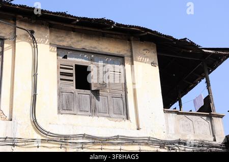 Maison locale à Zanzibar avec un câblage électrique pauvre et dangereux suspendu au bâtiment Banque D'Images