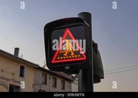 France – Panneau d'avertissement routier LED illuminé affichant un signal piéton lumineux sur un poteau de rue en ville. Banque D'Images