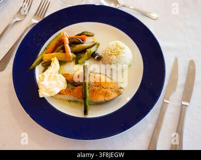 Belle portion de saumon saisi avec riz et légumes sur le côté Banque D'Images