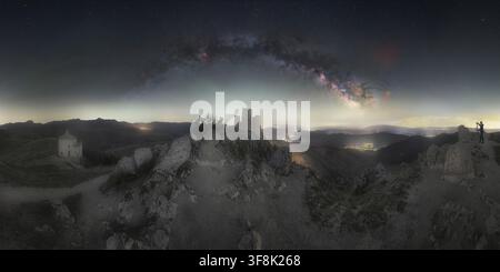 Vue de la forteresse historique de Rocca Calascio et de l'église sous la Voie lactée dans le ciel nocturne, avec un photographe sur le terrain rocheux à Calascio, Ab Banque D'Images