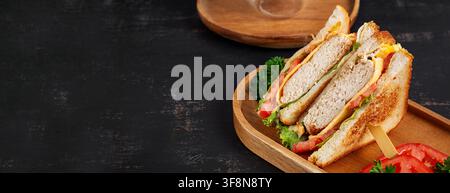Sandwich rustique pour le petit-déjeuner sur planche en bois avec espace libre pour le texte Banque D'Images