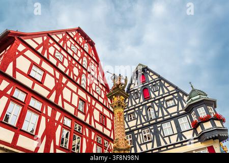 Vue en contre-plongée des maisons traditionnelles à colombages et d'une fontaine ornée d'une statue de chevalier dans la vieille ville historique de Rothenburg ob der Tauber, G Banque D'Images
