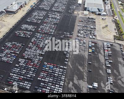 Nouvelles voitures en attente de distribution sur un parking extérieur dans une usine automobile Banque D'Images