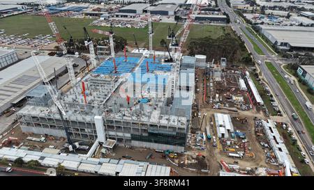 Vue aérienne d'un grand projet de construction dans une zone urbaine, montrant plusieurs grues et des machines lourdes en train de construire Banque D'Images