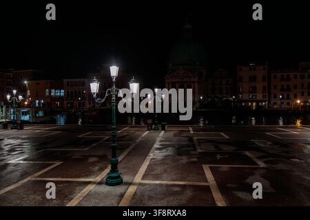 Photo de nuit d'un lampadaire illuminé sur la place de la gare de Santa Lucia avec l'église San Simeon Piccolo en arrière-plan, Venise, Italie Banque D'Images