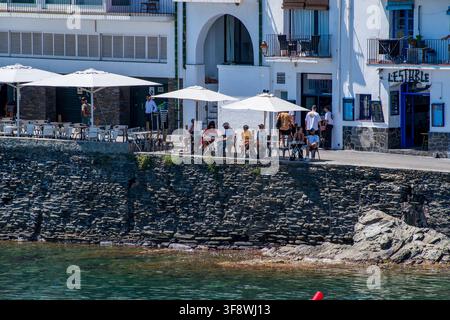 Touristes se détendant dans un café de bord de mer et sur la plage de Cadaqués, Catalogne, Espagne Banque D'Images