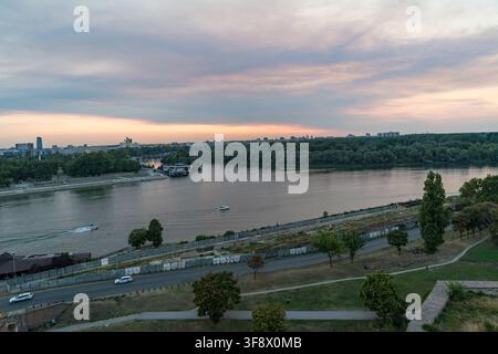 Une vue panoramique élevée de la confluence des rivières Sava et Danube à Belgrade, en Serbie, lors d'un coucher de soleil paisible. Le ciel est rempli d'un doux rose Banque D'Images