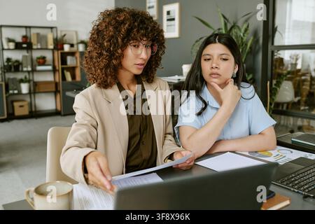 Des femmes d'affaires diverses travaillant sur un ordinateur portable dans un bureau moderne Banque D'Images