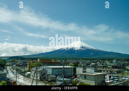 YAMANASHI, JAPON - 5 JUILLET 2025 : Vue panoramique du sommet volcanique du mont Fuji enneigé depuis la fenêtre d'un bus touristique en mouvement lors d'un voyage d'été. Banque D'Images