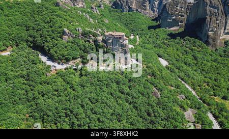 Vue aérienne du monastère orthodoxe de Rousanou construit au sommet d'une falaise escarpée entourée d'arbres d'une forêt dense, Meteora Kalabaka Grèce voyage st Banque D'Images