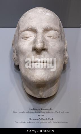 Landsberg, Allemagne - 25 juil. 26 : Masque mort en plâtre d’Hubert von Herkomer exposé avec une étiquette bilingue à l’intérieur du musée Mutterturm. Banque D'Images