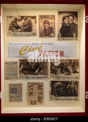 Bastone, Belgique – 21 juil. 25 : Vitrine de posters de films sur le thème de Bastogne et de souvenirs de cinéma au Musée de la Guerre de Bastogne en Belgique. Banque D'Images