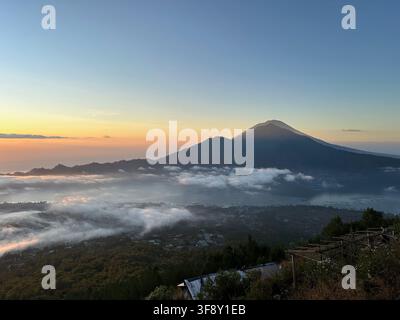 Le volcan Mont Agung s’élevant au-dessus de la mer de nuages à l’aube vu depuis le Mont Batur, Bali, Indonésie Banque D'Images