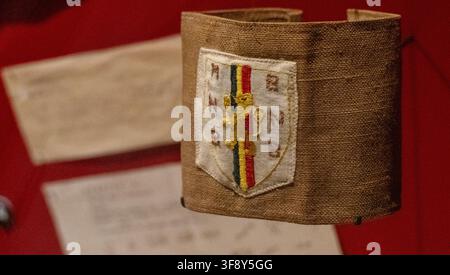 Bastogne, Belgique - 21 juil. 25 : Brassard de la résistance belge arborant les couleurs nationales exposé au Musée de la Guerre de Bastogne à Bastogne, Belgique. Banque D'Images