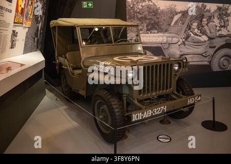 Bastogne, Belgique - 21 juil. 25 : Jeep militaire vert olive exposé à l'intérieur du musée de la guerre de Bastogne à Bastogne, en Wallonie, Belgique. Banque D'Images