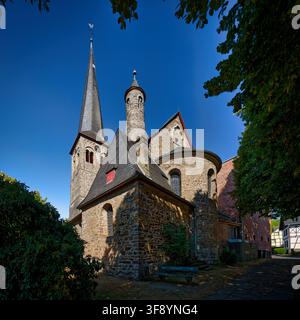 Architecture en pierre romane de l'église Sainte-Walburga avec un haut clocher à Overath. Ciel bleu clair. Banque D'Images