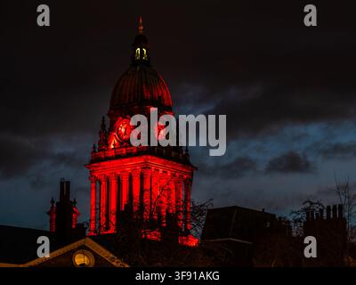 Vue de la tour de l'horloge de la mairie de Leeds illuminée en rouge la nuit Banque D'Images