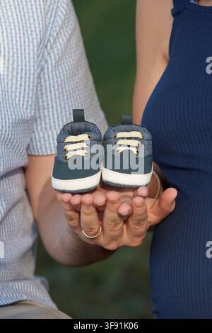 Chaussures de bébé dans les mains des parents Banque D'Images