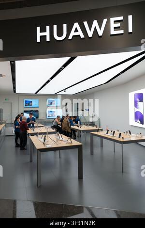 Shenzhen, Chine - 09 novembre 2025 : Des clients parcourent des smartphones et des appareils électroniques dans un magasin Huawei. Banque D'Images