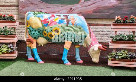 Sculpture de vache peinte avec une illustration de conte de fées dans le parc de la ville Banque D'Images