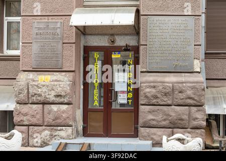 Kiev, Ukraine – 22 mars 2026 : La façade extérieure d'une bibliothèque publique arborant des plaques commémoratives en métal, marquant un centre d'éducation et de vie civique Banque D'Images