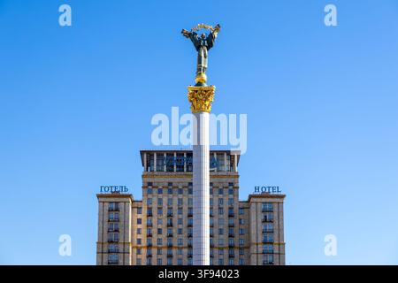 Kyiv, Ukraine - 15 mars 2026 : Une figure dorée de Berehynia est assise au sommet d'une haute colonne devant l'hôtel historique Ukraina, symbolisant la nationa Banque D'Images