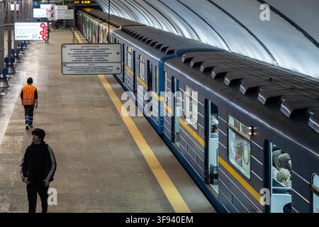 Kyiv, Ukraine - 15 mars 2026 : des navetteurs passent devant un train de métro moderne sur le quai d'une gare de la ville, soulignant un environnement de transport urbain typique Banque D'Images