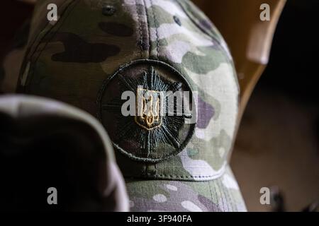 Kyiv, Ukraine - 15 mars 2026 : Chapeau de camouflage tactique arborant un patch trident brodé détaillé symbolisant la souveraineté et la défense de l'État Banque D'Images