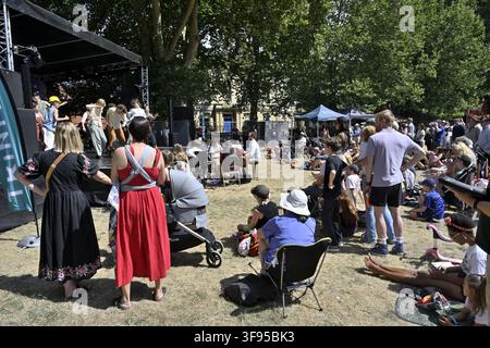 Public assis sur une pelouse regardant une représentation dramatique pour enfants sur scène dans un parc lors du festival de Bristol Harbour Banque D'Images