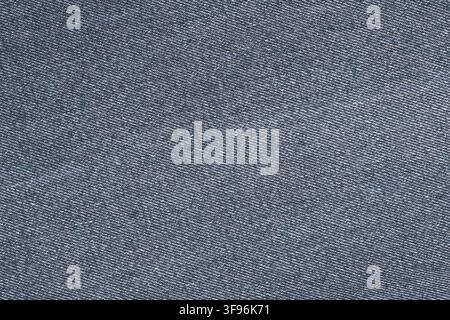 Fond en texture de tissu denim bleu. Gros plan d’un matériau en coton tissé pour jeans. Motif de surface textile pour la conception de vêtements ou arrière-plan de mode. Simple Banque D'Images