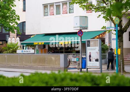 Une vue au niveau de la rue de l'entrée de la station de métro Alte Oper à Berlin, avec un auvent vert pour un café « Sunny Side Up » et une personne attendant à une Banque D'Images
