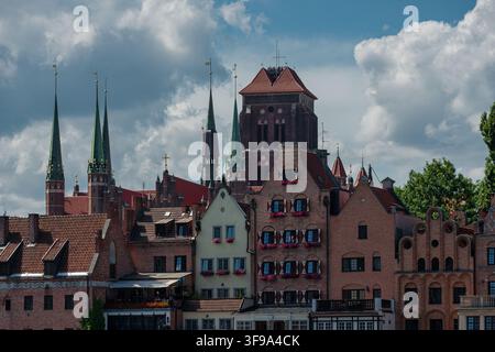 Une vue de la vieille ville historique de Gdańsk (Danzig) en Pologne, avec des maisons à pignons gothiques caractéristiques et des clochers d'église en arrière-plan. Banque D'Images