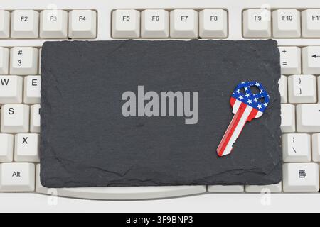 Tableau noir vierge avec une clé du drapeau américain sur un clavier d'ordinateur blanc pour l'achat de biens immobiliers en lignev Banque D'Images