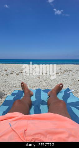 Détente sur la plage de Gaidaros à Kalamitsi, Lefkada, Grèce, où les sables dorés rencontrent des eaux turquoise cristallines, parfait pour bronzer et se détendre sous le soleil chaud. Banque D'Images