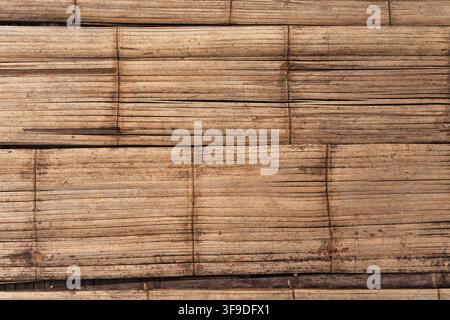 Panneaux de bambou aplatis et patinés disposés en couches horizontales créant un fond texturé naturel rustique Banque D'Images