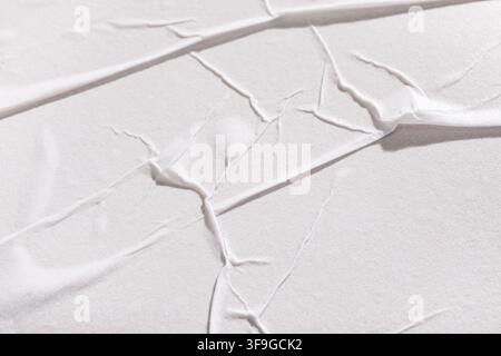 Fond en papier blanc froissé avec des plis et des rides abstraits, surface vierge d'affichage ou de panneau publicitaire Banque D'Images