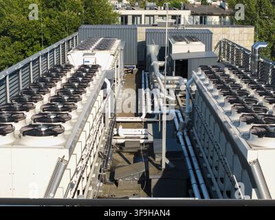 Vue aérienne d'un système de refroidissement d'un centre de données IA avec des ventilateurs HVAC industriels et des tuyaux sur un toit en Pologne. Banque D'Images