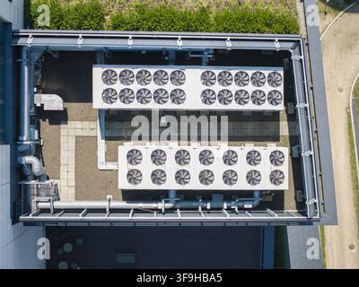 Vue aérienne d'unités de refroidissement HVAC industrielles avec plusieurs ventilateurs installés sur le toit d'un centre de données en Pologne. Banque D'Images