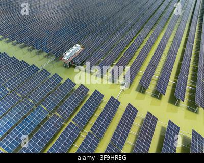 Vue aérienne du parc solaire de Sirajganj de 68 MW avec des rangées de panneaux photovoltaïques installés sur l'eau et l'infrastructure électrique à Sirajganj, Rajshahi Di Banque D'Images