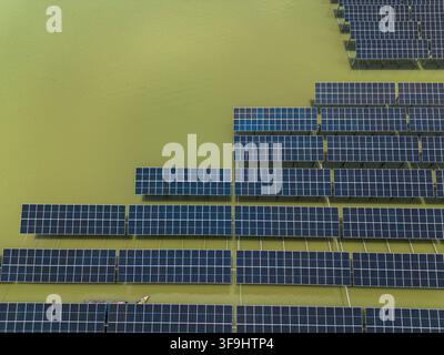 Vue aérienne du parc solaire de Sirajganj de 68 MW avec des rangées de panneaux solaires flottants sur la surface de l'eau à Sirajganj, division de Rajshahi, Bangladesh. Banque D'Images