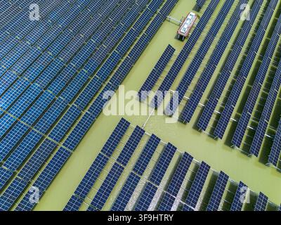 Vue aérienne du parc solaire de Sirajganj de 68 MW présentant des rangées de panneaux solaires flottants disposés selon des motifs géométriques sur l'eau à Sirajganj, Rajshahi Banque D'Images