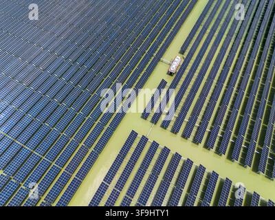 Vue aérienne du parc solaire de Sirajganj de 68 MW avec des rangées de panneaux photovoltaïques installés sur l'eau à Sirajganj, division de Rajshahi, Bangladesh. Banque D'Images